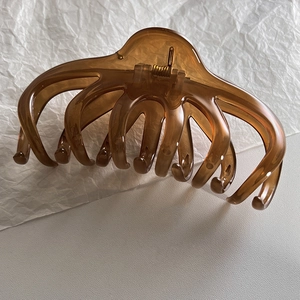 Detailed view of amber translucent large hair claw clip with multi-teeth design