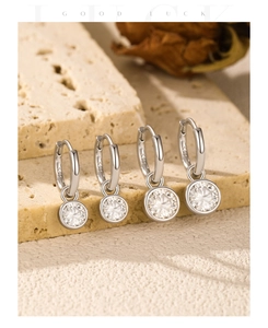 Detailed close-up of S925 sterling silver hoop earrings with moissanite on stone surface