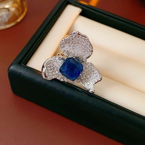 Detailed macro view of a vintage flower ring with blue square zircon in a jewelry box