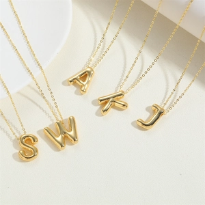 Detail of 3D bubble initial pendants S W A K J in polished 14K gold plating