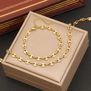 Elegant gold oval link chain necklace and bracelet set displayed in a jewelry box