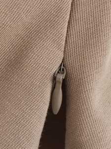 Macro shot of khaki knit fabric showing hidden zipper detail and fine texture