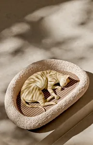 Dettaglio del tappetino in sisal resistente e bordo in morbido pile su questo letto per gatti