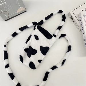 Detail of plush cow print water bottle bag with soft faux fur texture and shoulder strap