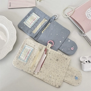 Flat lay of star-patterned canvas wallets with card slots, zipper and key ring