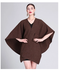 Brown wool poncho cape with side pockets and batwing sleeves worn over a black dress