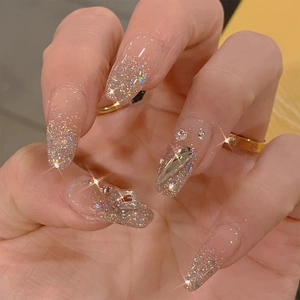 Macro shot of long coffin fake nails with silver glitter and sparkling rhinestones