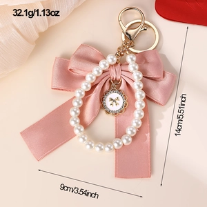 Detail view of pink bow keychain with pearl ring showing exact size 14cm and 32.1g weight