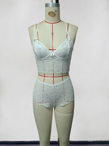 Détail d'un ensemble de lingerie en dentelle florale blanche avec petits nœuds