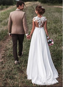Detailansicht des weißen Brautkleids aus Spitze und Chiffon mit Blumenstickerei und Knöpfen