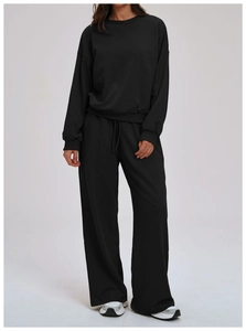 Detail of black long-sleeve sweatshirt and drawstring wide-leg pants on model