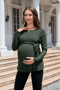 Detailed close-up of dark green ribbed knit texture and adjustable waist tie on maternity sweater