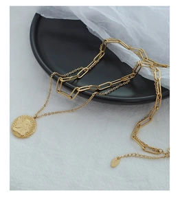 Detail of double-layer gold necklace featuring cupid angel coin pendant and K18 tag