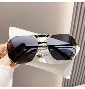 Detail der polygonalen Goldmetallbrille mit dunkelgrauen UV-Schutzgläsern