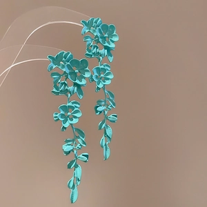 Elegant teal long floral drop earrings with a summer vacation style detail view.
