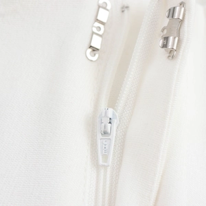 Vita di pantaloni bianchi strutturati con cerniera invisibile e gancio metallico di chiusura
