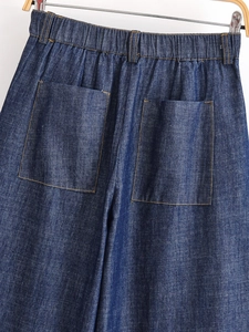 Detail of dark blue denim jeans featuring elastic waistband and double rear patch pockets
