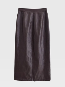Détail de la texture d'une jupe en cuir marron chocolat et de sa ceinture assortie