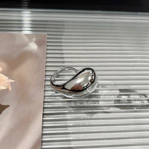 Macro shot of 3D silver waterdrop ring with polished finish on textured glass