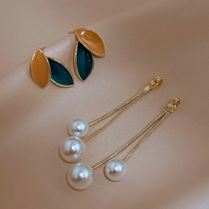 Vintage leaf earrings with pearls and colorful tassels on a warm silk background