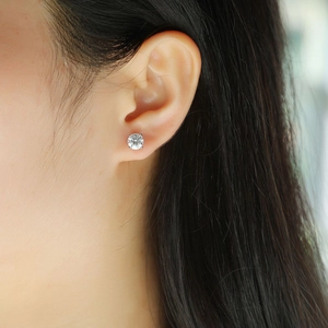 Close-up of a classic silver four-prong stud earring with a round-cut clear cubic zirconia