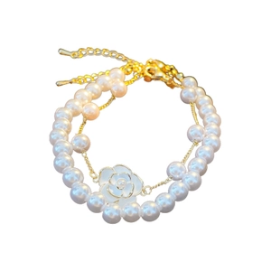 Double-layered gold bracelet featuring imitation pearls and a camellia flower pendant