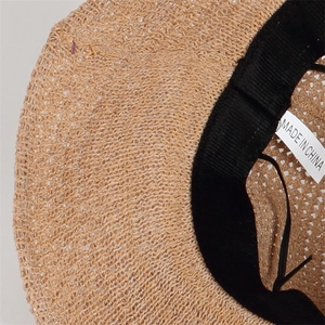 Détail du tissage de paille kaki avec bandeau intérieur noir et étiquette d'entretien