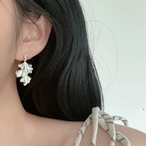 Silver-plated pleated leaf earrings worn by a model for a chic and minimalist look