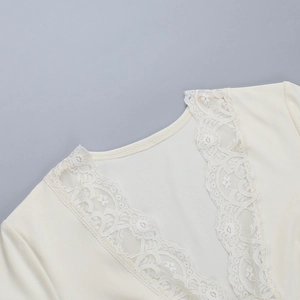Détail de l'encolure en V avec dentelle élégante sur un haut en maille beige chic
