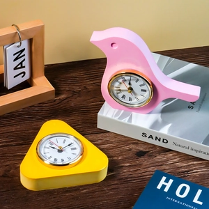 Detail of bird and geometric desk clocks with Roman numerals and matte finish