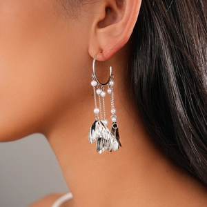 Detail of silver long tassel earrings with pearls and wing charms on model side profile