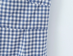 Nahaufnahme von blau-weißem Gingham-Stoff mit feinen Nähten und Textilstruktur