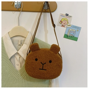 Detailed view of a cute brown plush bear crossbody bag for kids on a lifestyle background