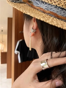 Detail showing elegant teardrop earring with beige wood grain stone and silver multi-bead cuff