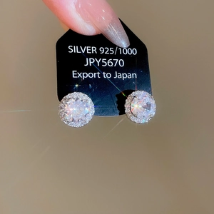 Macro detail of 925 silver stud earrings with sparkling round cubic zirconia stones