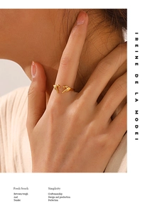 Close-up of a minimalist gold open ring with creative finger-pointing ends on a hand