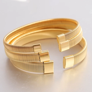 Detail view of three 6mm gold stainless steel flexible wire bracelets with square end caps