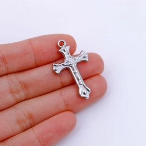 Detailed view of a silver stainless steel crucifix pendant with a Jesus relief carving