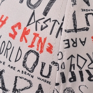 Detailed view of gray canvas baseball cap with red SKIN and black graffiti print