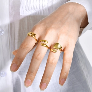 Close-up of three gold stainless steel rings worn by a model with cubic zirconia details