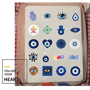 Detail of assorted evil eye and bohemian stickers applied to a white tablet surface