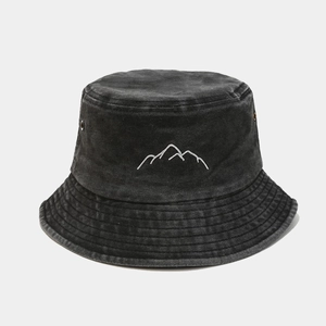 Detailed mountain embroidery on washed denim fabric of a vintage dark grey bucket hat
