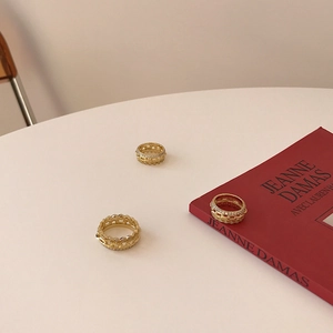 Three gold-plated S925 silver chain rings with sparkling cubic zirconia on a minimalist desk