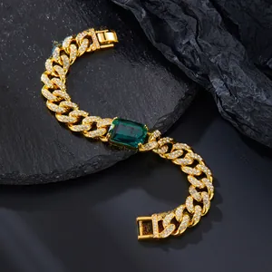 Dettaglio bracciale cubano dorato con cristalli e pietra preziosa verde smeraldo