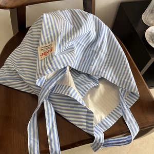Borsa tote capiente in cotone a righe bianche e blu su una sedia di legno