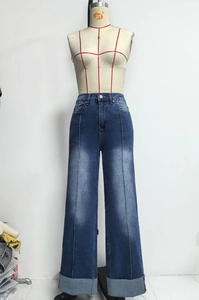 Detail van high-waist jeans met wijde pijpen, voornaad en brede omgeslagen rafelige randen