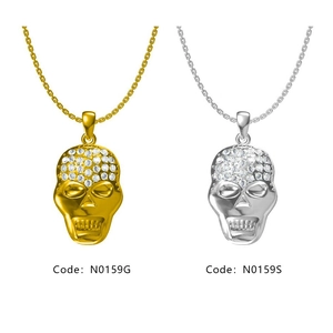 Détail de pendentifs tête de mort hip hop en or et argent avec pavé de cristaux brillants