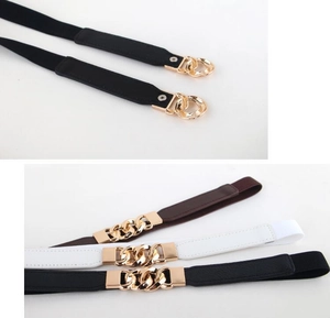 Detail of elastic waist belts featuring gold chain buckles in black, brown, and white
