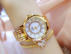 Detail of gold floral watch with mother of pearl dial and matching bow bracelet