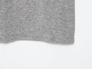 Detailed macro view of the double-stitched hem on a grey knitted midi skirt set